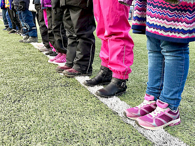 lasten kengät rivissä urheilukentällä